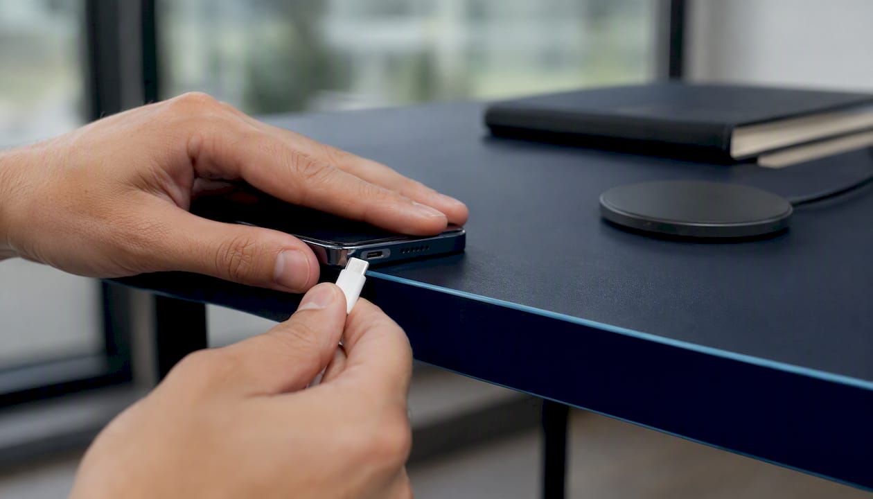 Hands unplugging smartphone charging cable