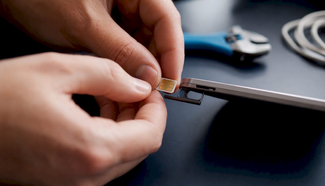 Hands inserting SIM card into smartphone