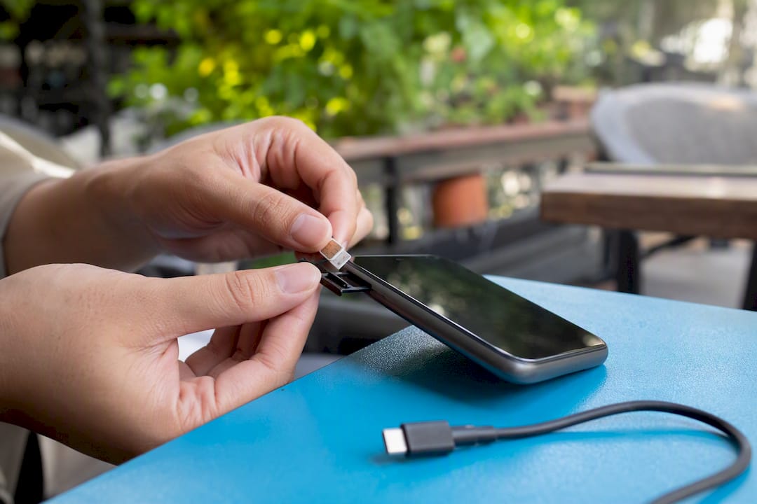 Hands inserting SIM card into smartphone