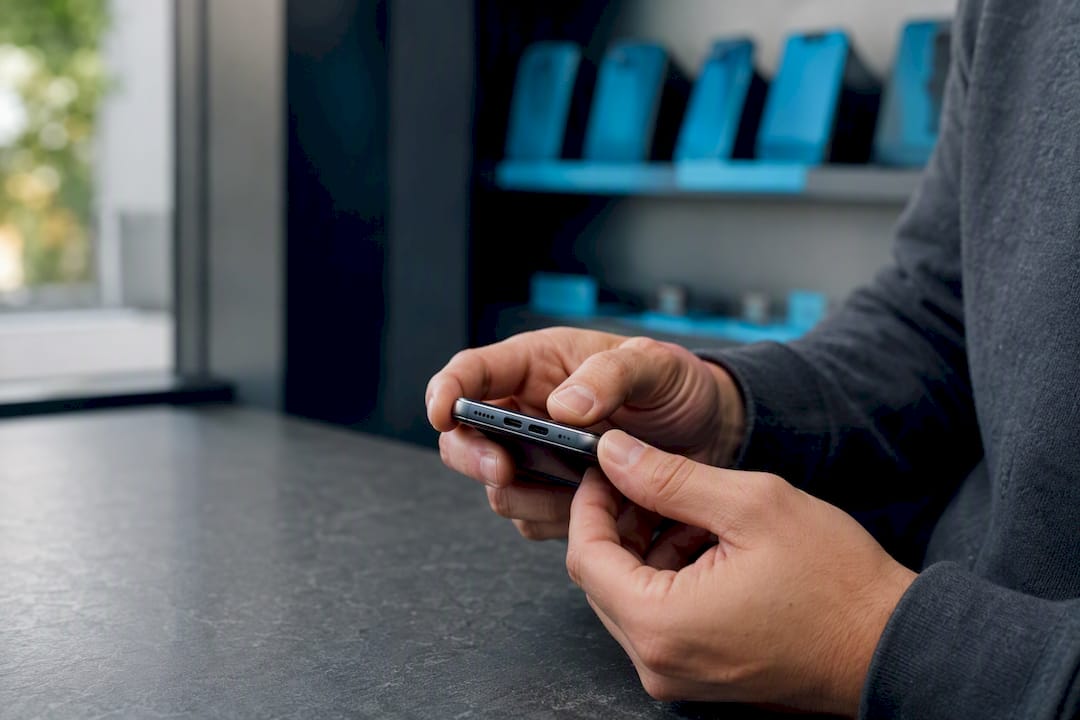 Hands inspecting refurbished smartphone edges