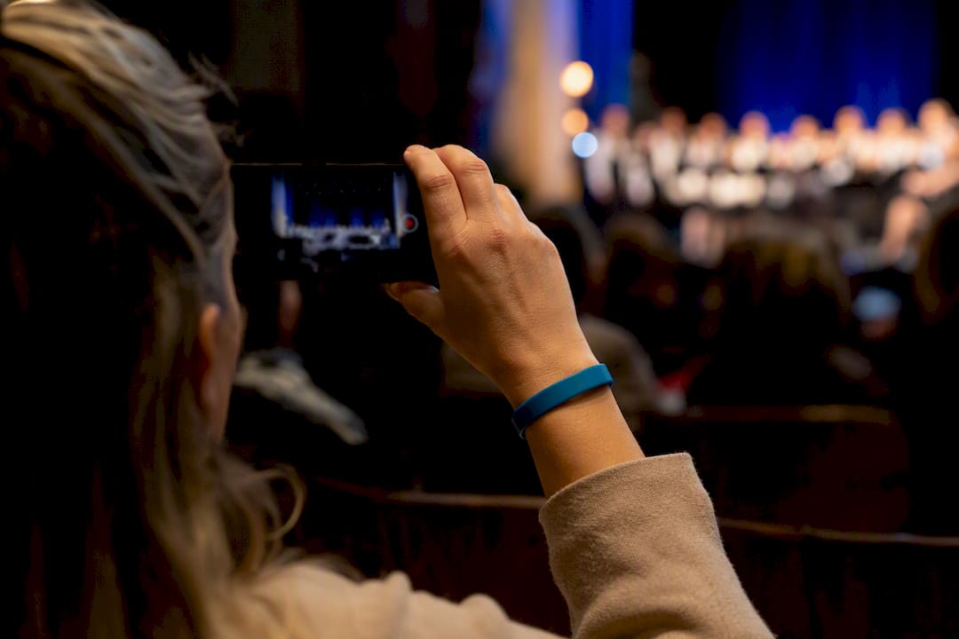 Parent recording recital video on phone