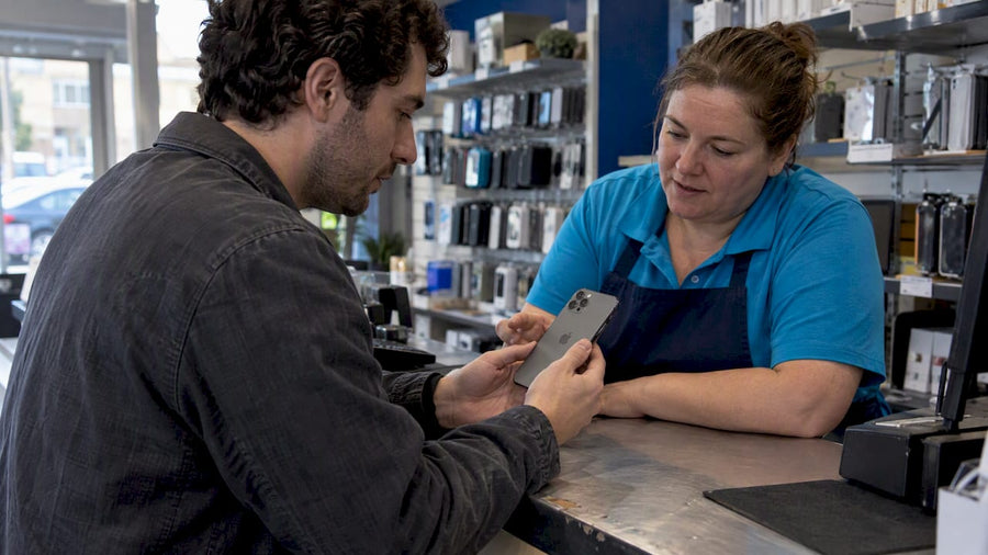 Buyer and associate inspect a refurbished iPhone